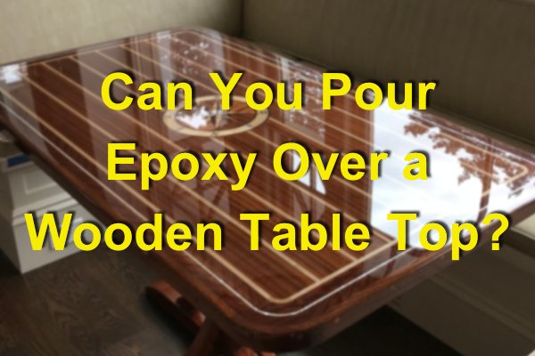 A blurred photo of a wooden epoxy table top with a text overlay that says "Can You Pour Epoxy Over a Wooden Table Top?"